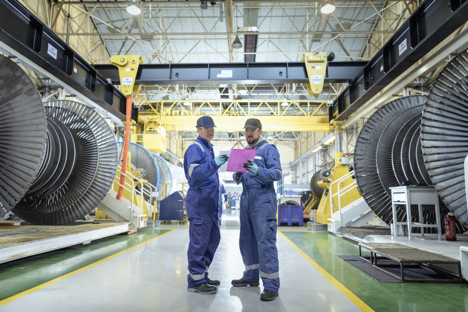 Engineers in discussion in turbine maintenance factory